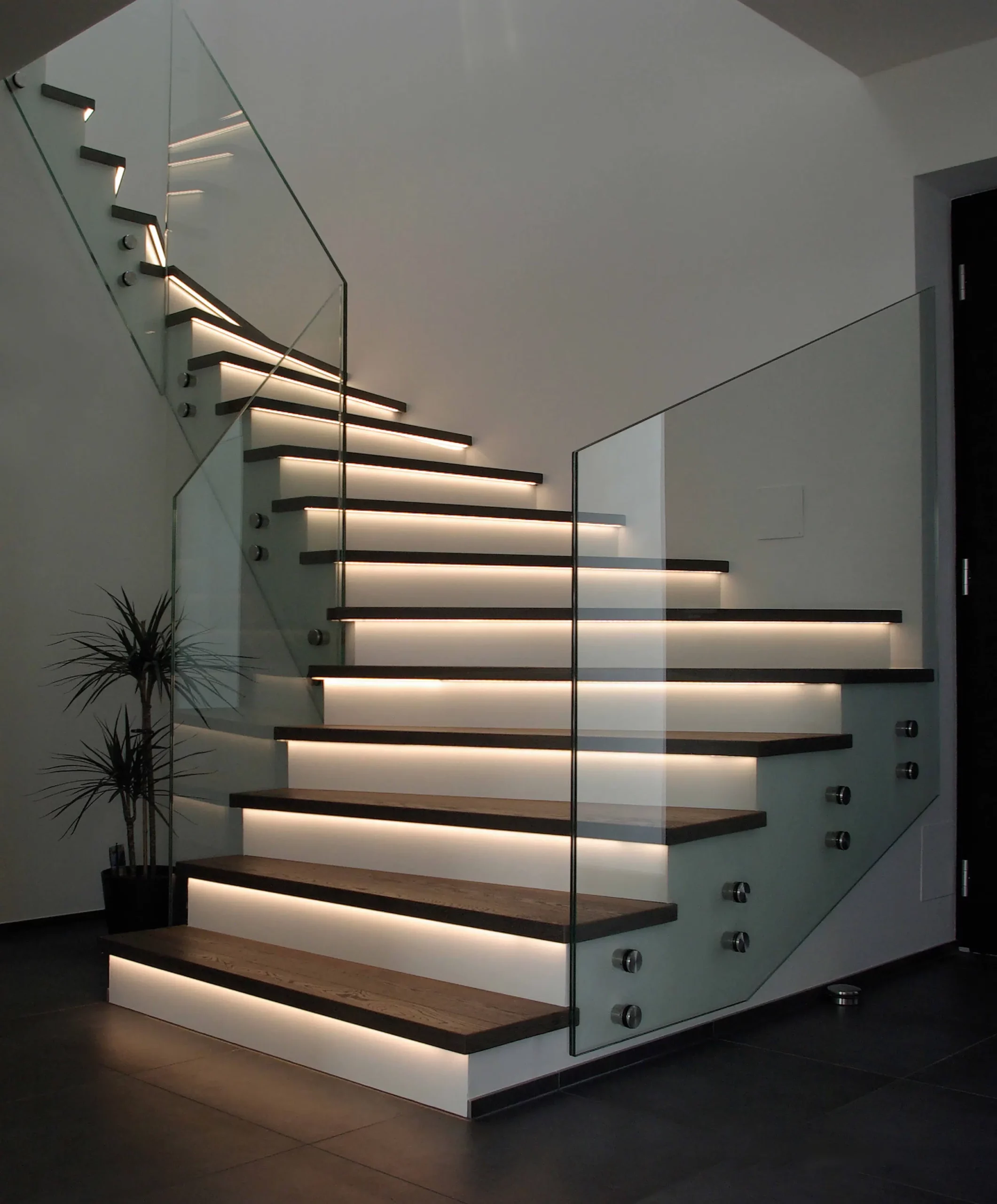 Eine moderne Treppe mit Glasgeländer und LED Beleuchtung an den Treppen - Stufen. Fussbodentechnik Schwallach -Bodenbeläge, Vinylbelag, Parkett - Neckaraue 7 - 71686 Remseck